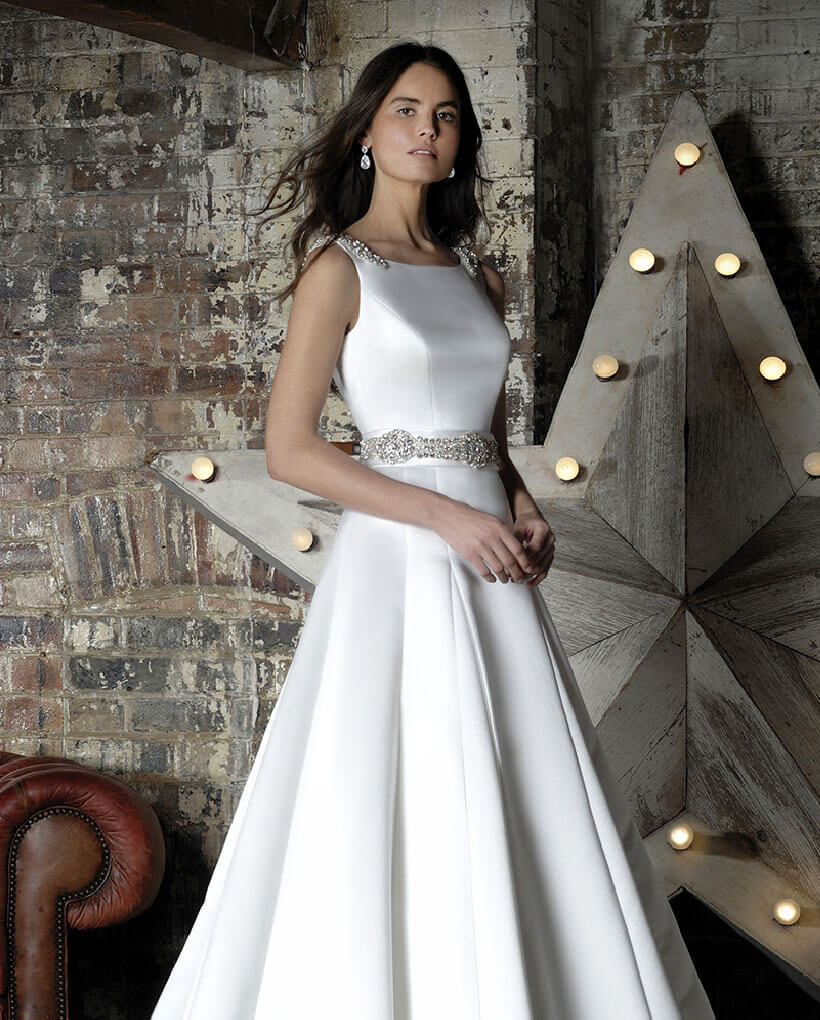 Model wearing a white Margaret Moreland Dress